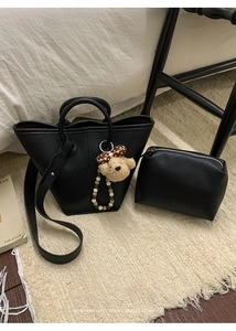Détail du sac en cuir litchi noir avec breloque ours en peluche et pochette interne