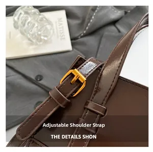 Close-up of a dark brown glossy leather bag with adjustable golden metal strap buckle