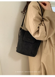 Détail du sac cabas en cuir mat noir avec logo embossé et boucles métalliques dorées