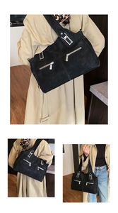 Close-up of black suede tote bag with silver zippers and wide shoulder straps