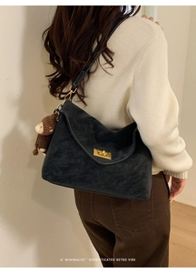 Detail of retro underarm bag with white stitching and cute brown bear pendant