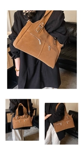 Close-up of vintage brown tote bag featuring dual front zip pockets and metal buckles