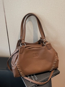 Brown lychee leather tote bag with braided edges and ao embossed detail on books