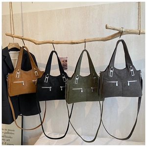 Detail view of large tote bags in four colors with dual zipper pockets and matte texture