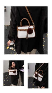 Detail showing woven bucket bag with brown leather trim, strap and furry pendant