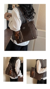 Detail of coffee brown suede tote bag with contrast stitching and bear charm