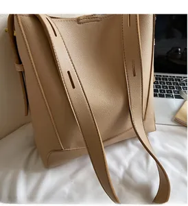 Detail of light khaki pebble leather bucket bag featuring a wide comfortable shoulder strap