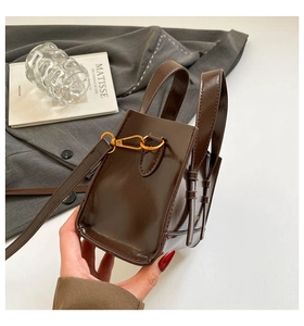 Detail of a dark brown glossy vintage handbag showing side profile and metal buckles