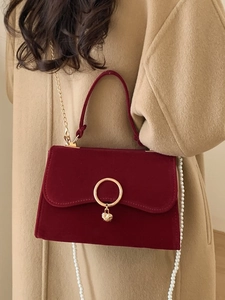 Elegant burgundy velvet handbag with golden ring closure and pearl chain strap for women