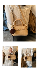 Detailed view of beige textured bucket bag with leather trim and brown pompom charm
