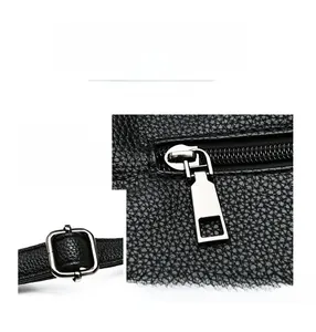 Detail of silver hardware and lychee pattern leather texture on a black tote bag