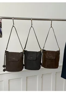 Trois sacs seaux minimalistes en cuir mat aux couleurs café, noir et marron clair