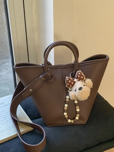 Sac seau marron foncé à texture litchi avec pendentif ours et bandoulière large