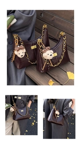 Detail of deep brown glossy leather hobo bag with gold chain strap and bear charm
