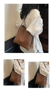 Detail of soft leather bucket bag featuring reinforced triangular stitching and brown pebble grain