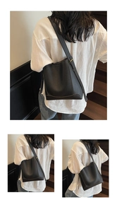 Detail of black pebbled leather bucket bag showing adjustable strap and golden hardware