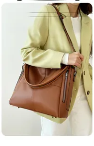 Brown lychee leather tote bag featuring side zipper pocket and adjustable strap detail