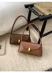 Detail of vintage baguette bags in dark and light brown with golden metal oval buckles