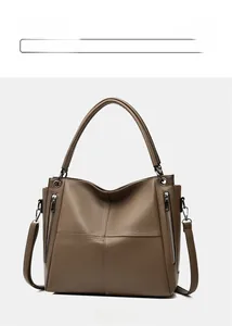 Detail view of khaki large capacity leather tote with lychee grain texture and metal zippers