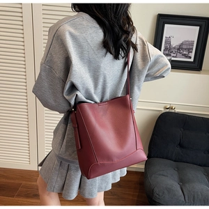 Detailed view of dark burgundy leather bucket bag showing soft texture and large capacity