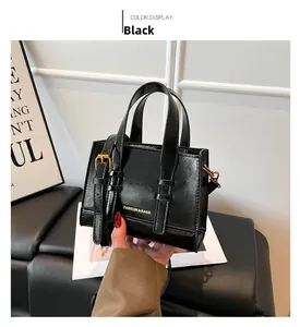 Detail of black crossbody bag with gold FASHION & BAGS text and adjustable strap