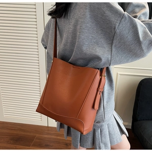 Brown bucket bag in pebbled leather with adjustable strap shown from a back view