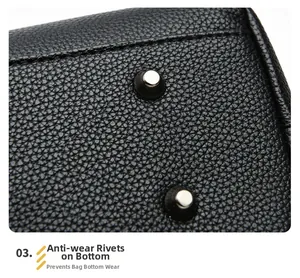 Close-up of silver metal feet on black lychee leather tote bag bottom for protection