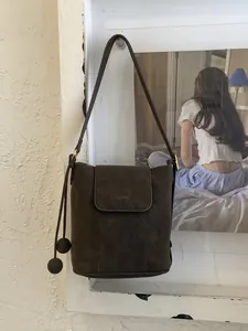 Sac seau en cuir mat marron foncé avec cordons décoratifs et bandoulière longue réglable