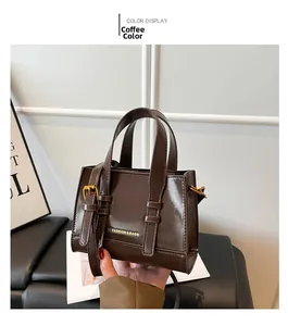 Detail view of coffee brown PU leather bag featuring gold buckles and adjustable strap