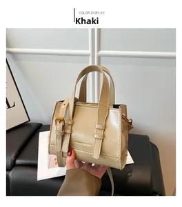 Detail of khaki faux leather handbag featuring a gold Fashion & Bags logo and slim handle