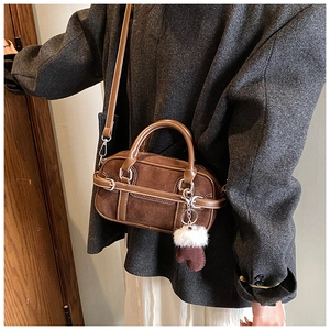Détail du sac bowling en daim café avec breloque gant en peluche et bandoulière