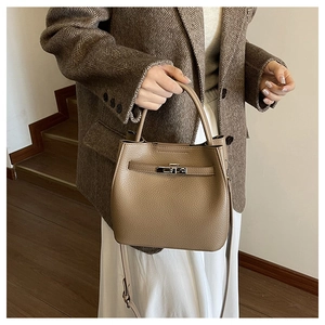 Detail of caramel lychee grain leather bucket bag with silver lock and leather strap