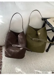 Détail de grands sacs hobo vintage en cuir mat de couleur café et vert olive