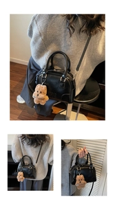 Detail of black leather Boston bag with plush bear charm and metallic gold hardware
