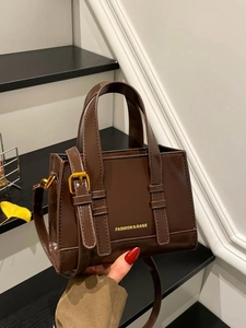 Deep brown glossy leather tote bag with top handles and adjustable shoulder strap