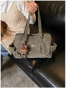 Detail of army green large tote bag with retro matte texture and punk zipper accents