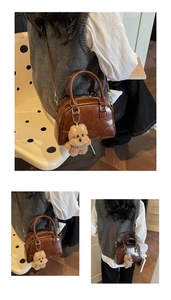 Detailed view of brown retro Boston bag with glossy texture and plush bear pendant