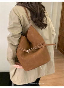 Vue détaillée du sac seau marron rétro avec lanière décorative et boucle métal