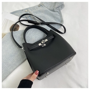 Top view of black pebbled leather handbag with cat-ear silhouette and silver turn-lock
