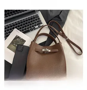 Detailed size comparison of dark brown litchi pattern bucket bag with laptop and phone
