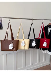 Selection of four chic leather tote bags in various colors with cute plush bear charms