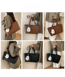 Detail view of large tote bags in black and brown with plush bear pendant accessories