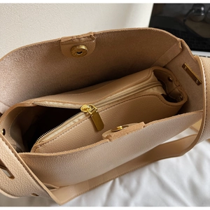 Detailed top view of the spacious bucket bag interior with a matching zipper pouch