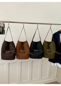 Vue détaillée de grands sacs seaux en marron, caramel, noir et vert olive foncé