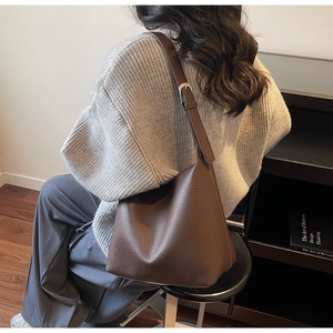 Detail of soft dark brown lychee grain leather shoulder bag with adjustable strap