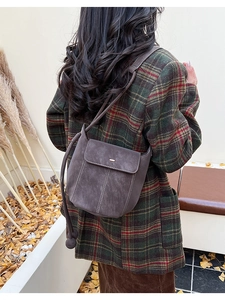Outdoor shot showing the retro dark brown bucket bag on model with contrast stitching