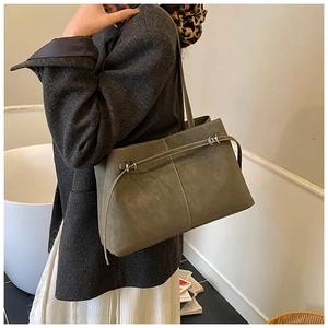 Detail of the olive green tote bag with matte texture and decorative metallic buckle