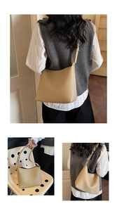 Detail of beige lychee grain leather hobo bag with adjustable strap and textured finish