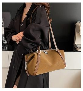 Nahaufnahme der karamellbraunen Boston-Tasche mit Nietengurten und strukturierter Lederoptik