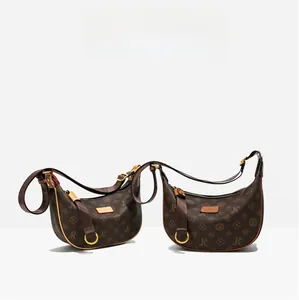 Detail of vintage monogram hobo bags with golden hardware and wide fabric straps